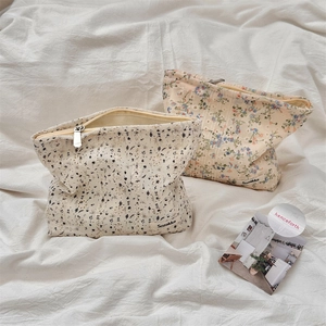 Close-up of floral canvas makeup bags with metal zippers and woven Sozakka labels