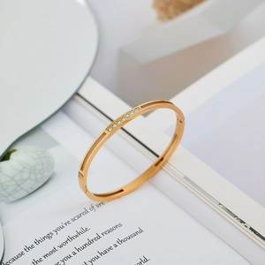 Detailed view of a gold-plated stainless steel bangle set with white zircon stones