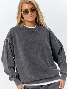 Detailed texture of washed black cotton sweatshirt showing premium vintage fabric finish