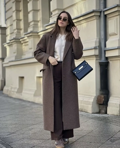 Detail of long brown wool blend coat featuring classic lapels and single-breasted design
