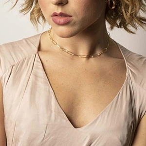 Classic golden stainless steel paperclip chain necklace worn by a model in a close-up