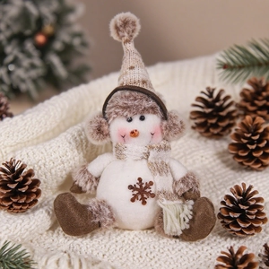 Close-up of a cozy knitted snowman figurine with a coffee-colored scarf and ear muffs