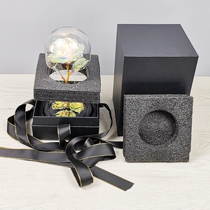 Detail view of gold foil rose in glass dome with LED lights and elegant black gift box