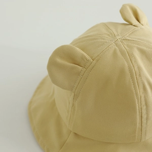 Detailed macro view of cotton baby sun hat with cute decorative ears and twill fabric texture