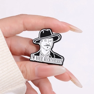 Cartoon enamel pin featuring a cowboy hat man with I'M YOUR HUCKLEBERRY quote