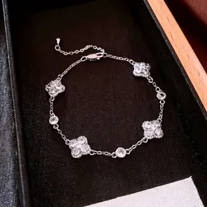 Elegant silver four-leaf clover bracelet with white zircon stones on a black velvet box