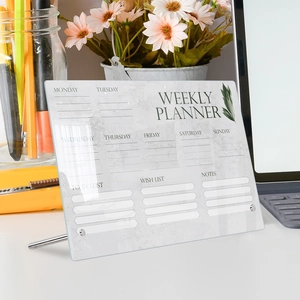 Macro view of clear acrylic weekly planner with metal stand on office desk