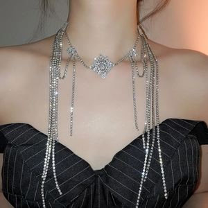Close-up of a silver tassel necklace with zircon floral pendant and sparkling chains