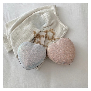 Detail of glittery heart-shaped evening bags in silver and pink with gold chain straps