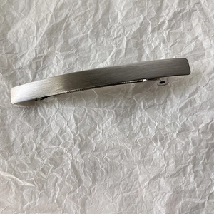 Detailed view of long minimalist spring hair clip with brushed silver alloy texture