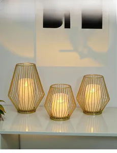 Three geometric gold iron candle holders with warm LED lights for home decor