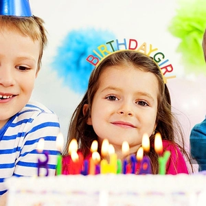 Detail of a girl wearing a colorful Birthday Girl letter headband at a party