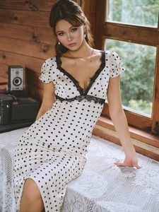 Close-up of French vintage white polka dot dress featuring elegant black lace stitching