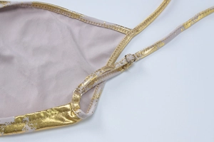 Detailed macro view of golden foil print straps and adjustable silver metal buckles on dress