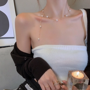 Elegant long Y-shaped gold pearl necklace with long tassel pendant for women on model