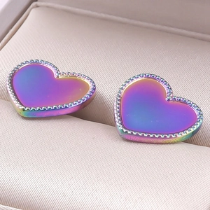 Macro shot of rainbow gradient heart-shaped earrings with fine beaded edge detail