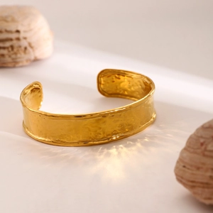 Macro detail of 18k gold plated stainless steel cuff bracelet with hammer texture surface
