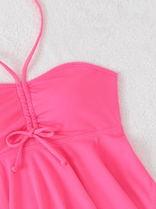 Close-up of ribbed neon pink halter swim top with ruched center and bow detailing