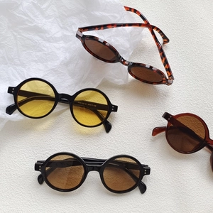 Retro round frame sunglasses with tinted lenses and tortoiseshell finish on white background
