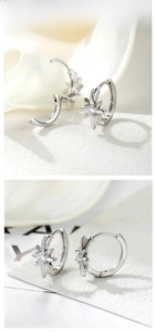 Detail of silver star hoop earrings featuring sparkling white zircon stone inlay