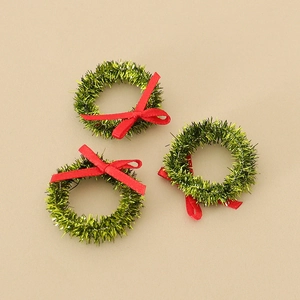 Three mini green glitter Christmas wreaths with red bows for DIY holiday crafts