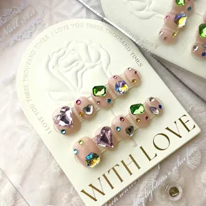 Luxury handmade press-on nails featuring colorful gemstones and crystals on pink base