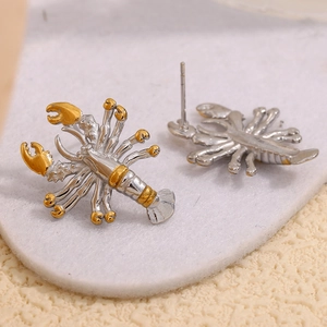 Detailed macro view of creative lobster-shaped stud earrings in silver and 18K gold finish