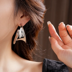 Polished silver geometric C-shape earrings on model for an elegant minimalist style