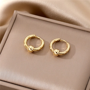 Detail of gold hoop earrings with small round beads on a silk background