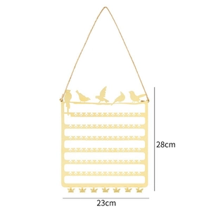 Golden wall-mounted metal jewelry organizer with bird accents and hooks for display