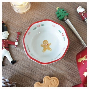 Close-up of a Christmas ceramic bowl featuring a gingerbread man and red scalloped rim