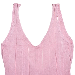 Détail macro de la texture tricotée rose avec motif ajouré vertical et décolleté en V