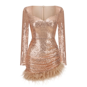 Close-up of champagne gold sequin dress featuring ostrich feather trim and slim fit