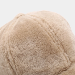 Close-up of thick plush fleece texture and stitching on a warm winter baseball cap