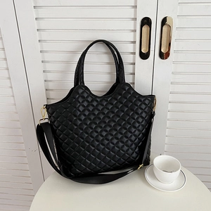 Chic black quilted tote bag with golden hardware and adjustable strap for urban women