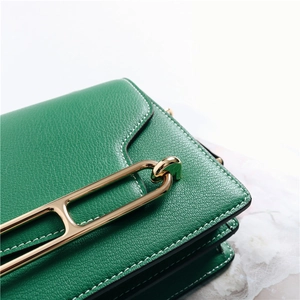 Macro di borsa in pelle verde con fibbia in metallo dorato e cuciture a contrasto