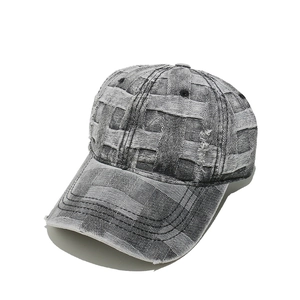 Close-up of distressed denim baseball cap with checkered woven texture and frayed edges