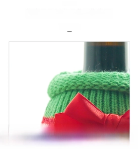 Detailed view of Christmas wine bottle cover with green knit collar and red ribbon bow