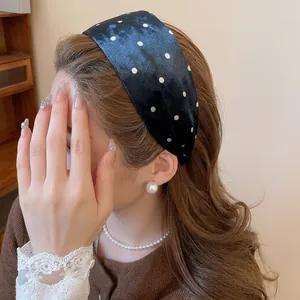 Polka dot wide headband in black velvet fabric worn by a model for a vintage look