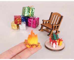 Close-up of miniature wooden rocking chair and colorful Christmas gift box models