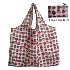 Detail view of foldable strawberry print shopping bag showing compact folded state