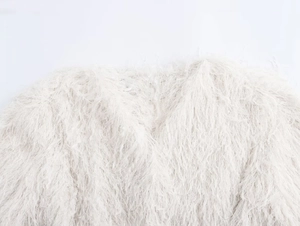 Vue détaillée macro de la texture de fausse fourrure blanche d'une veste femme