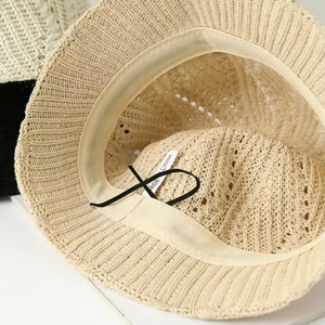 Detail view of knitted bucket hat featuring breathable hollow patterns and adjustable drawstring
