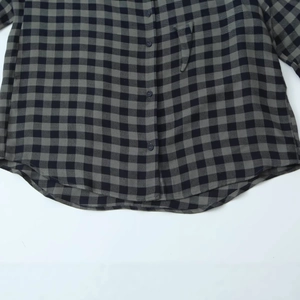 Front view of gray plaid long sleeve shirt featuring button-down front and curved hemline