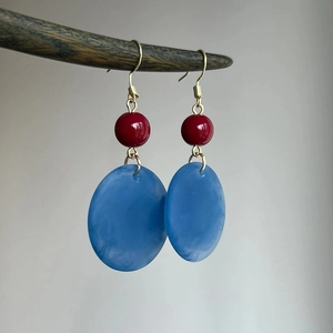 Gros plan de boucles d'oreilles vintage en acrylique avec perles rouges et bleues.