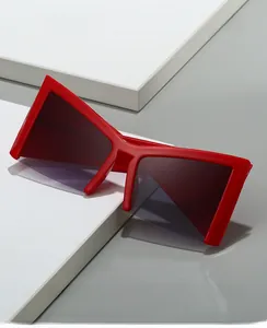 Detailed view of oversized red geometric frames with dark grey gradient lenses sunglasses