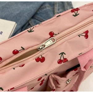 Detailed shot of pink tote bag featuring cherry print and high-quality YKK metal zipper