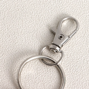 Close-up of a silver metal swivel hook and key ring chain accessory on a white background