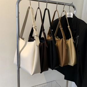 Close-up of minimalist tote bags in five colors with adjustable silver hardware straps