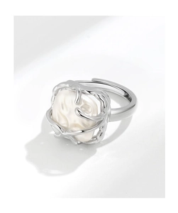 Detail of adjustable silver ring featuring a natural baroque pearl on white background